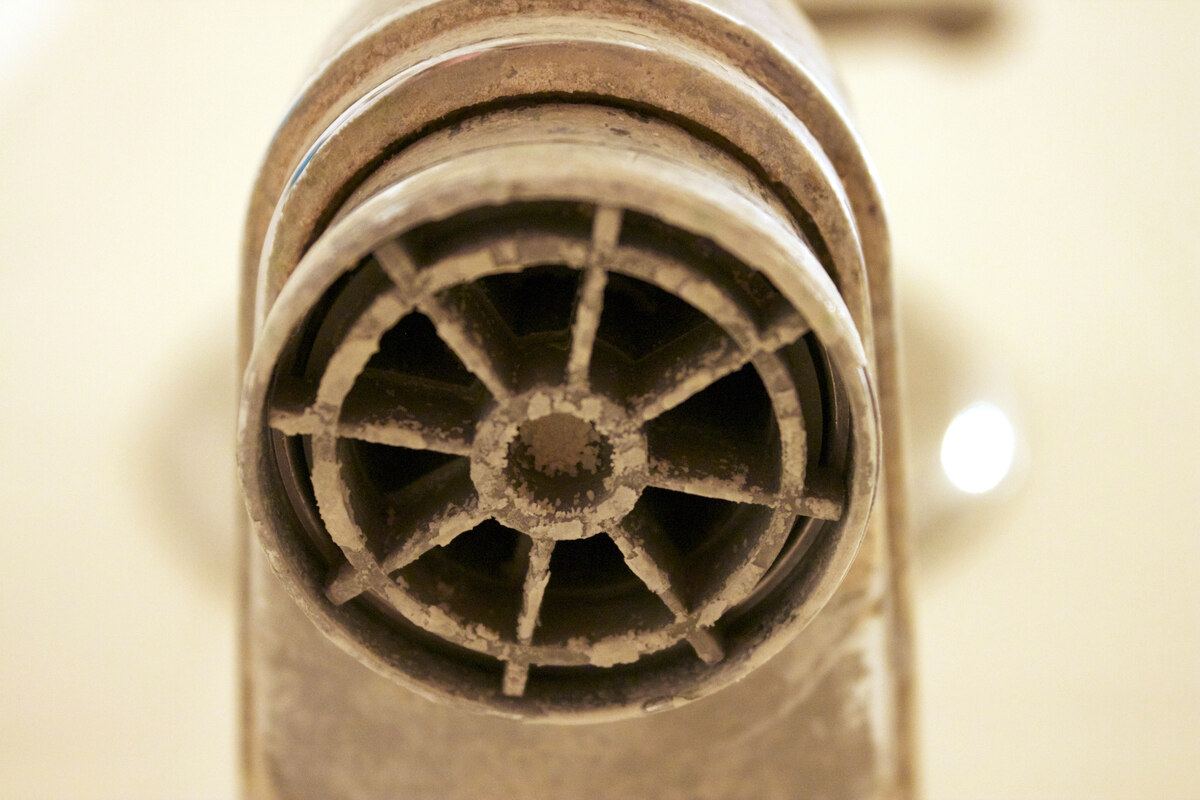 Close-up of chalky limescale deposits around a bathroom tap outlet